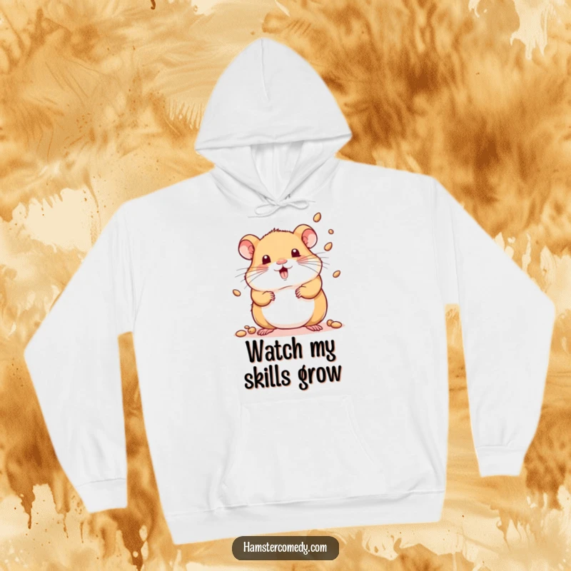 Funny hoodie with a kawaii hamster playfully juggling several tiny seeds with impressive dexterity.
